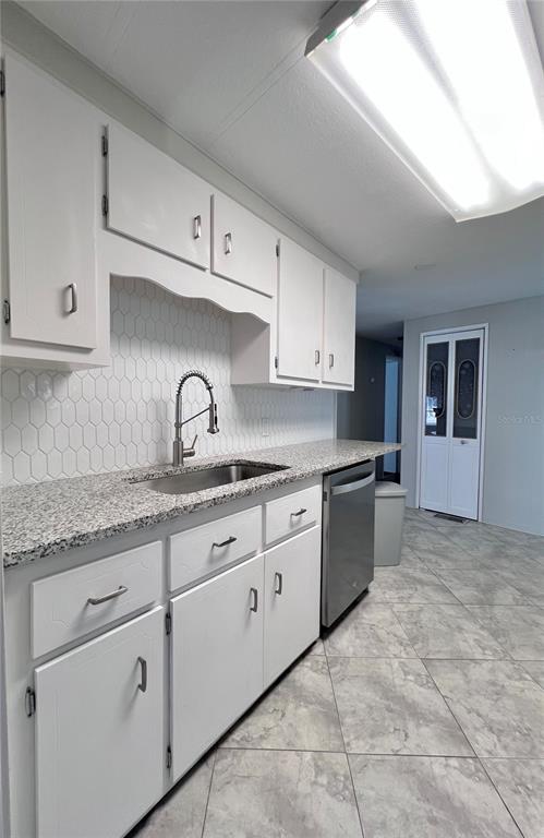 1100 South Belcher Road, Unit 772 Largo, FL 33771 - Photo 24 of 84 a kitchen with granite countertop white cabinets and stainless steel appliances