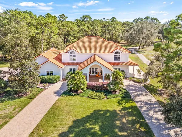a aerial view of a house next to a yard