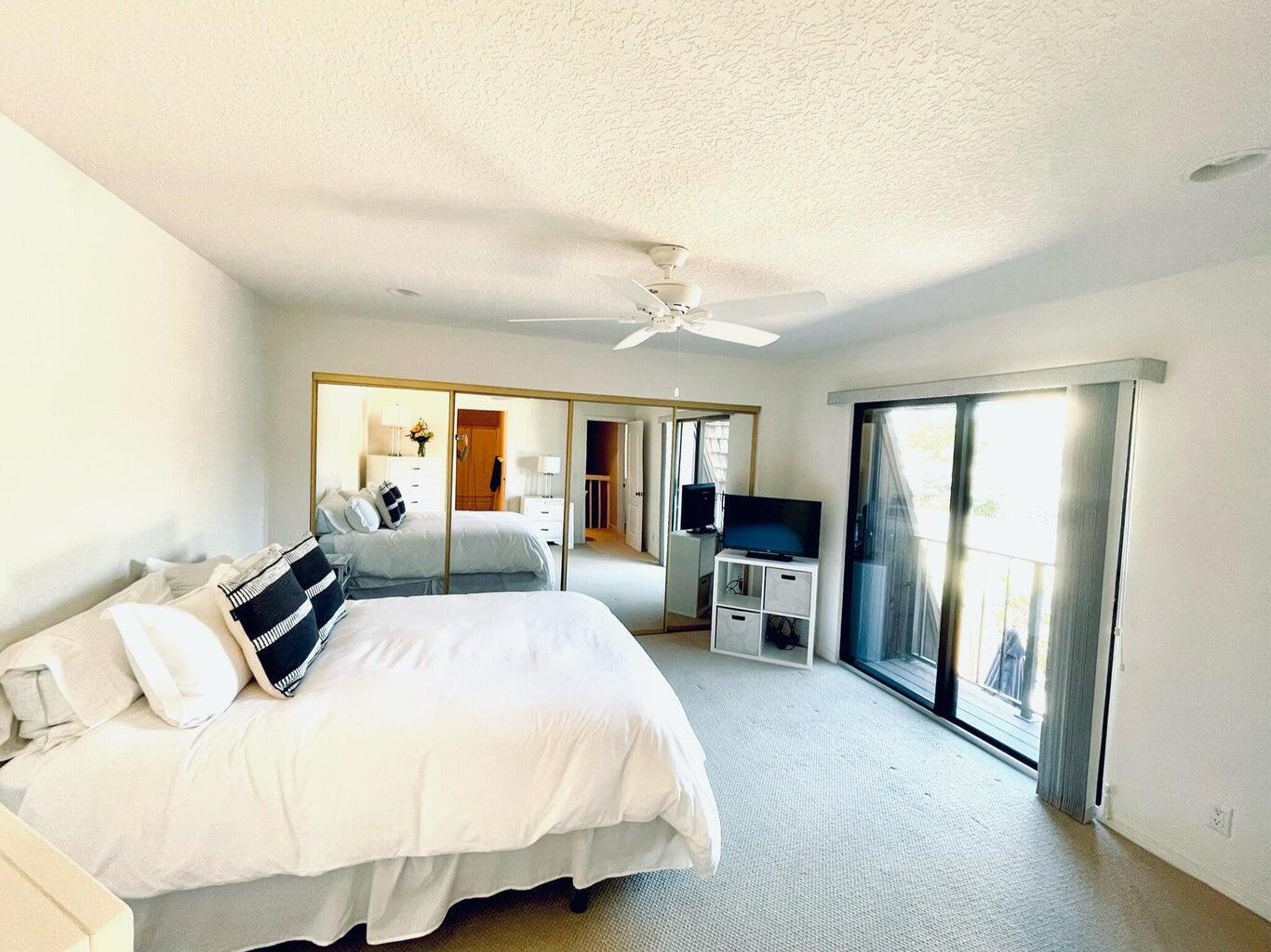 1420 Ocean Way Drive, Unit 32C Jupiter, FL 33477 - Photo 18 of 25 a bedroom with a bed and a chandelier