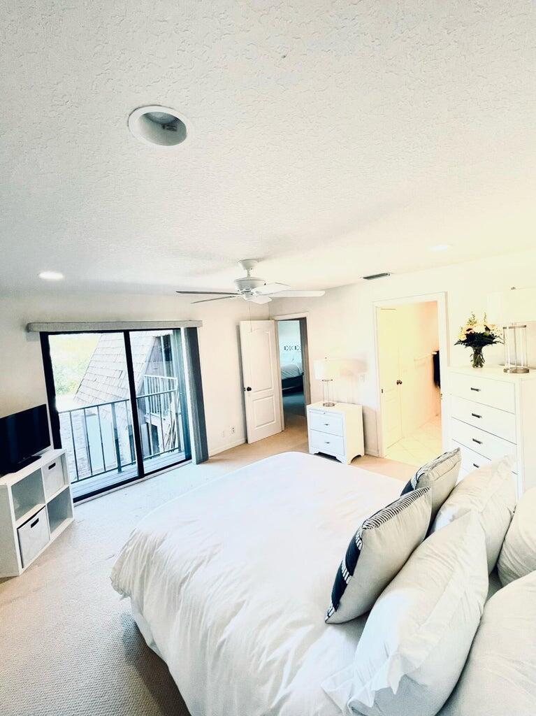 1420 Ocean Way Drive, Unit 32C Jupiter, FL 33477 - Photo 19 of 25 a bedroom with a large bed and a window