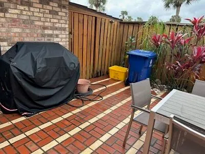 a view of backyard with table and chairs and potted plants