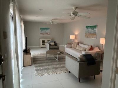 1420 Ocean Way Drive, Unit 32C Jupiter, FL 33477 - Photo 9 of 25 a living room with furniture and a chandelier