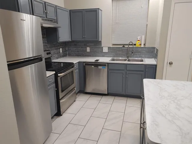 a kitchen with stainless steel appliances granite countertop a refrigerator a sink a stove a microwave and island