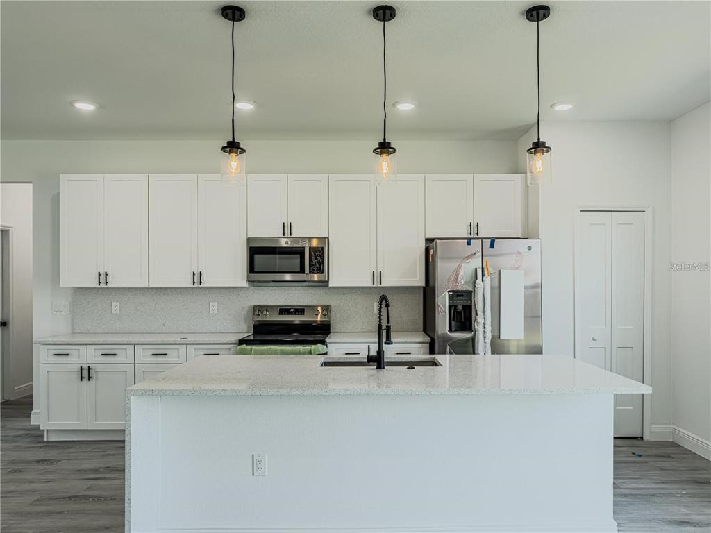 14245 Southwest 28th Court Ocala, FL 34473 - Photo 29 of 84 a view of a kitchen with stainless steel appliances granite countertop a refrigerator a sink a stove and white cabinets
