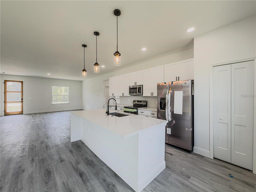 14245 Southwest 28th Court Ocala, FL 34473 - Photo 30 of 84 a kitchen with refrigerator and microwave