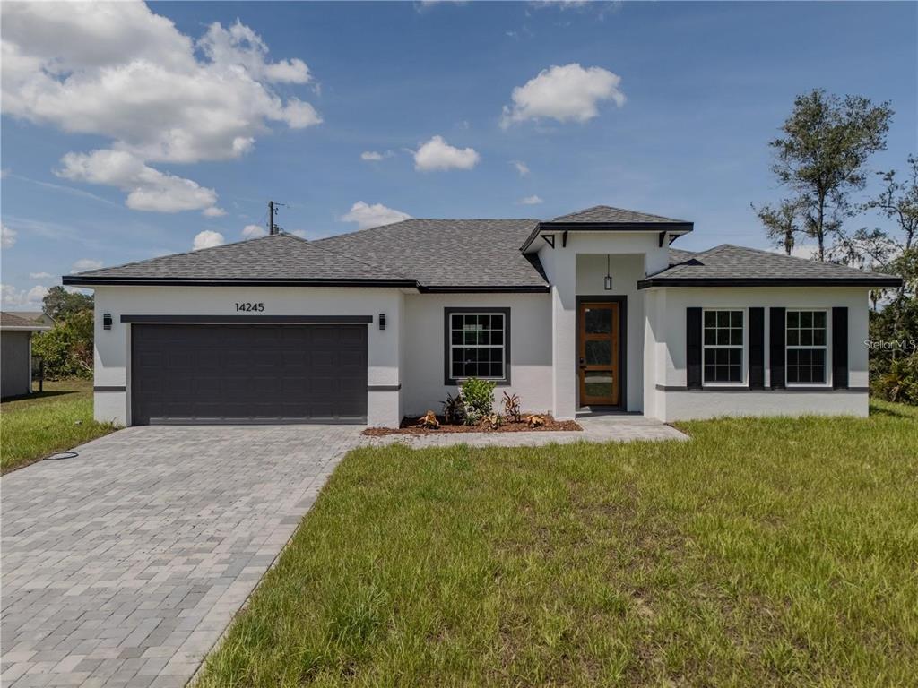 14245 Southwest 28th Court Ocala, FL 34473 - Photo 4 of 84 a front view of a house with a garden and yard