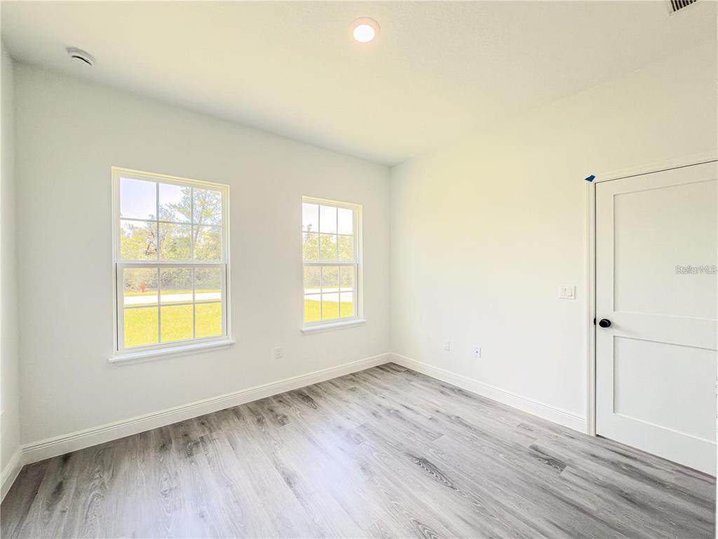 14245 Southwest 28th Court Ocala, FL 34473 - Photo 58 of 84 a view of an empty room with wooden floor and a window
