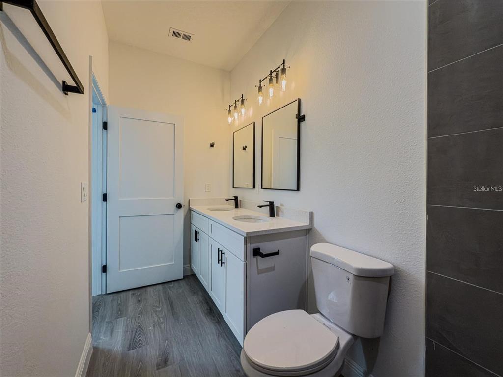 14245 Southwest 28th Court Ocala, FL 34473 - Photo 73 of 84 a bathroom with a toilet a sink a mirror and a shower