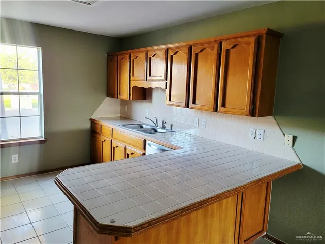 a room with a sink a stove and a window