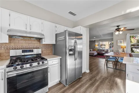 a kitchen with stainless steel appliances a stove a refrigerator and a fireplace