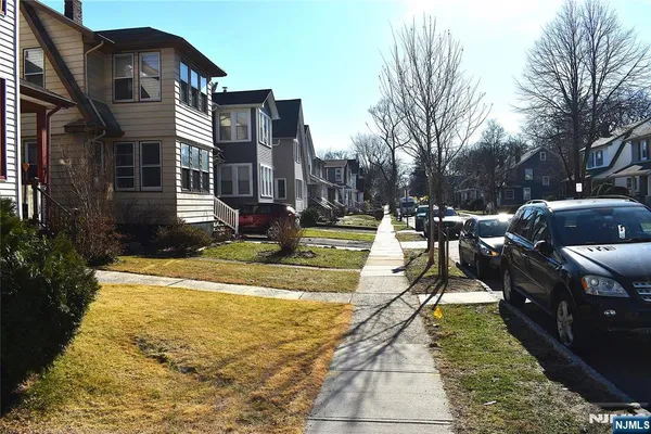 a view of a yard with cars on the road