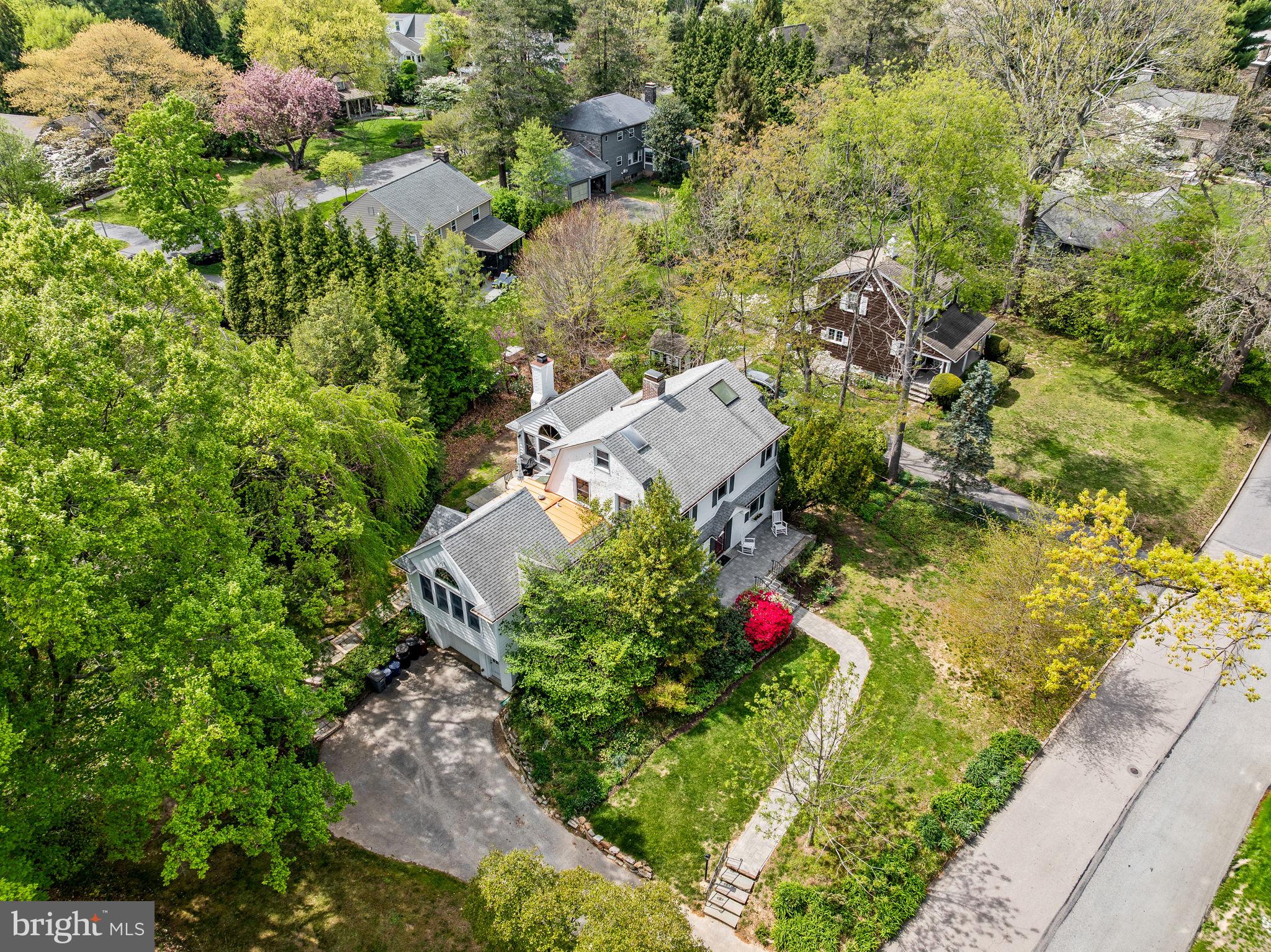 an aerial view of residential house with outdoor space and trees all around