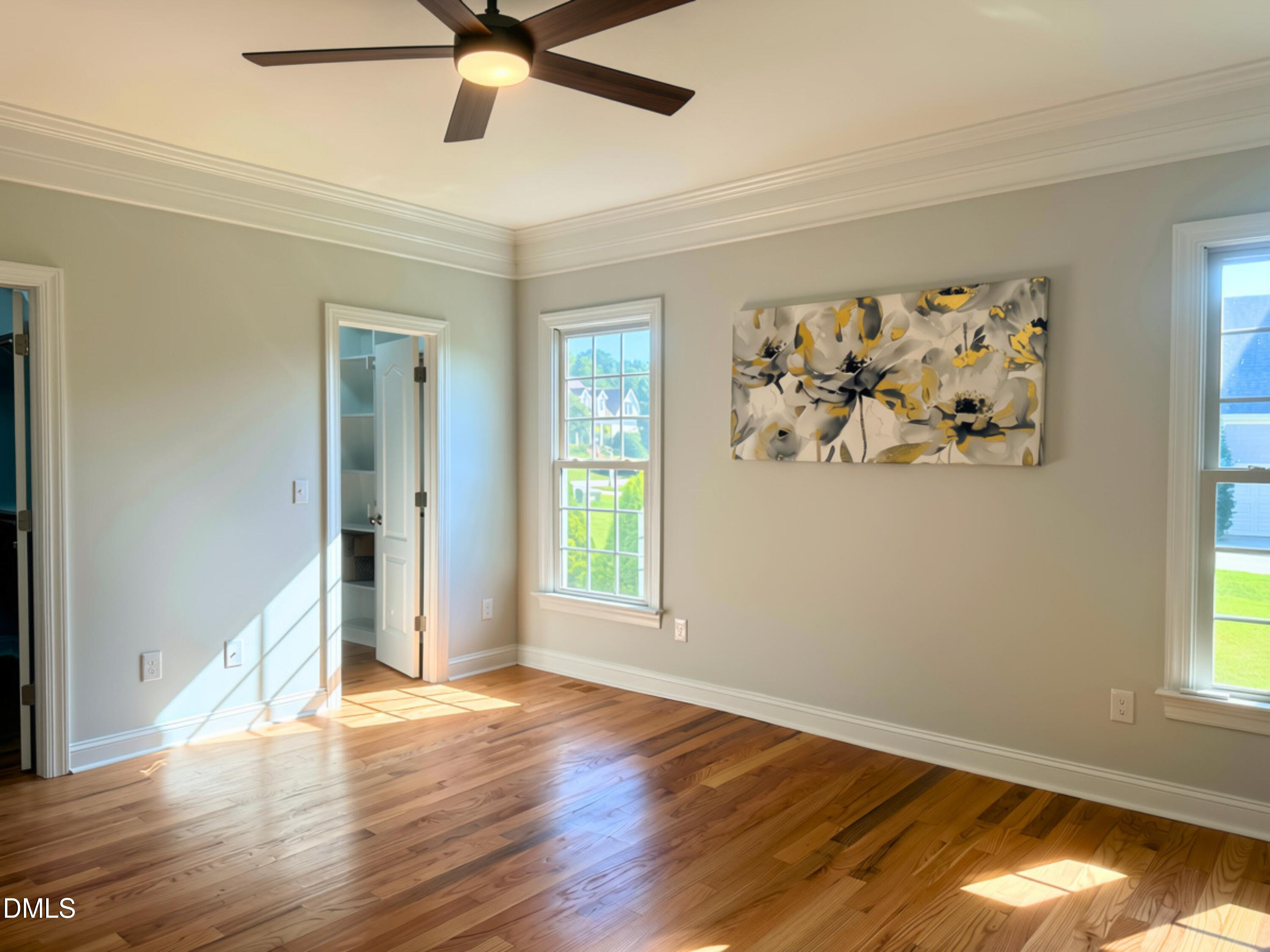 3100 Donlin Drive Wake Forest, NC 27587 - Photo 21 of 67 Hardwood flooring, crown molding, ceiling fan with integrated lighting, built-in shelving, and multiple windows