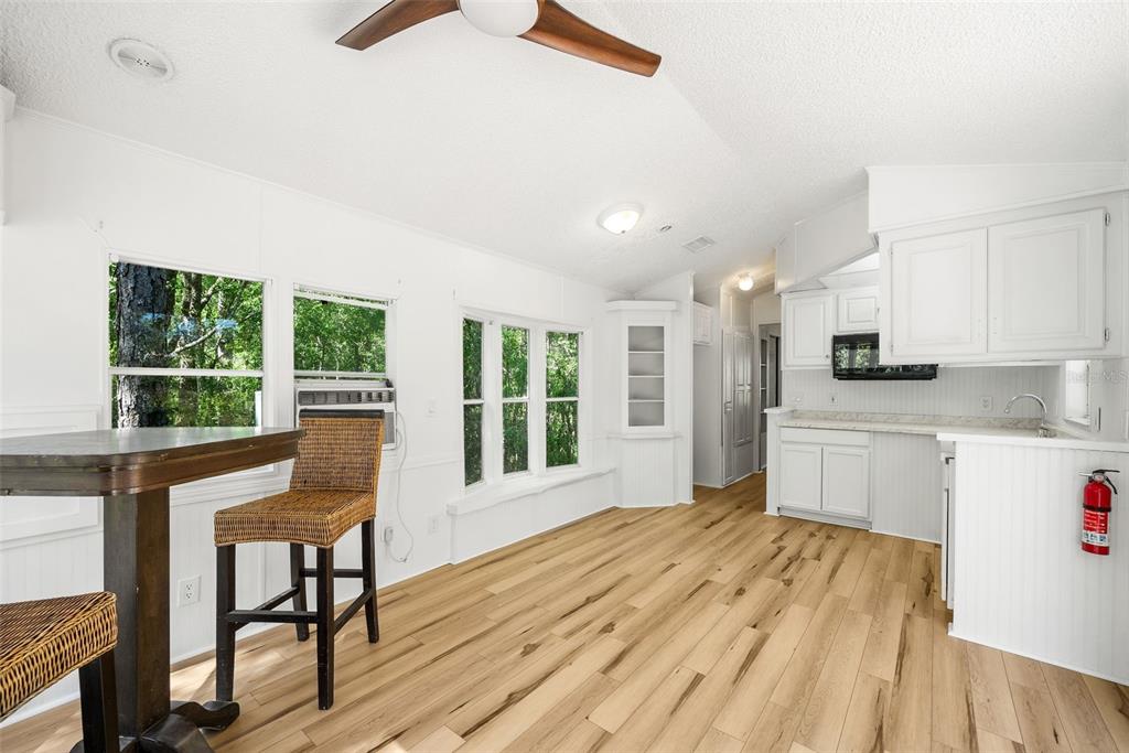 25723 Bareva Road Weeki Wachee, FL 34614 - Photo 40 of 55 a kitchen with stainless steel appliances granite countertop a stove a refrigerator a sink dishwasher with a dining table and chairs with wooden floor