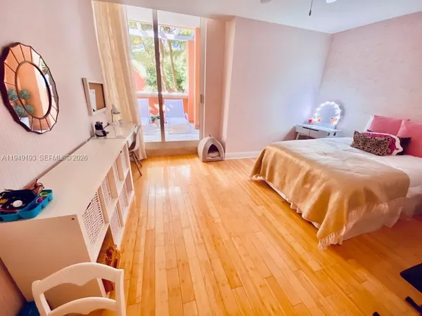 a bedroom with a bed and a potted plant on the dresser