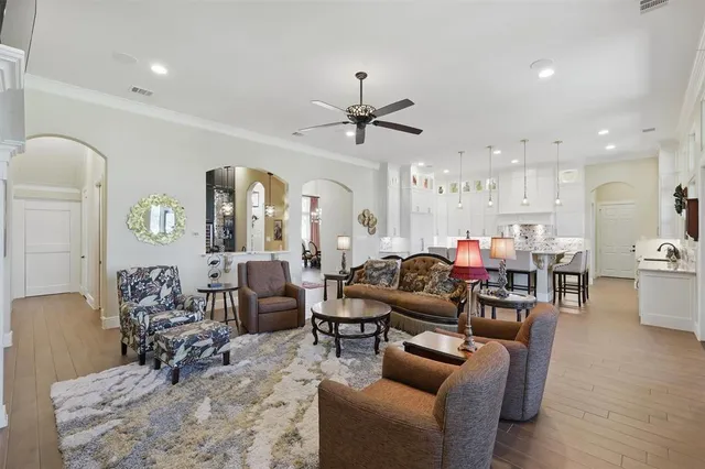 a living room with furniture kitchen view and a chandelier