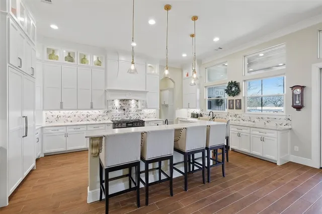 a kitchen with center island wooden floor cabinets and a dining table