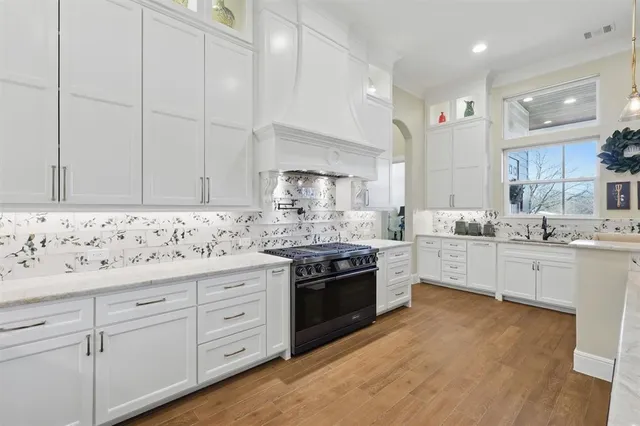 a kitchen with granite countertop white cabinets and white stainless steel appliances