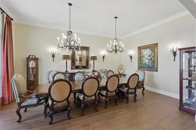 a view of a dining room with furniture a chandelier and wooden floor