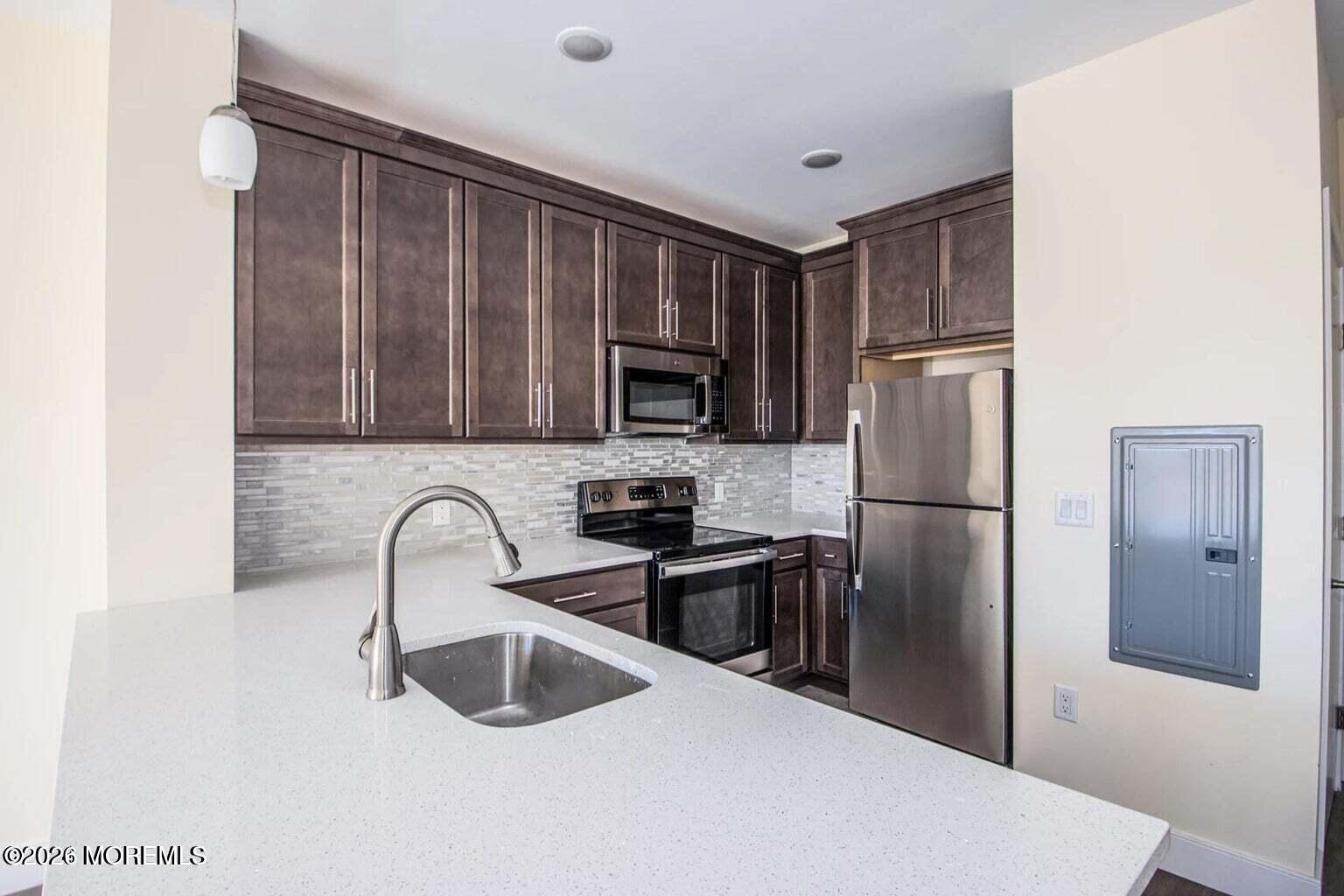 126 Main Street, Unit 311 Matawan, NJ 07747 - Photo 5 of 13 a kitchen with stainless steel appliances granite countertop a refrigerator and a sink
