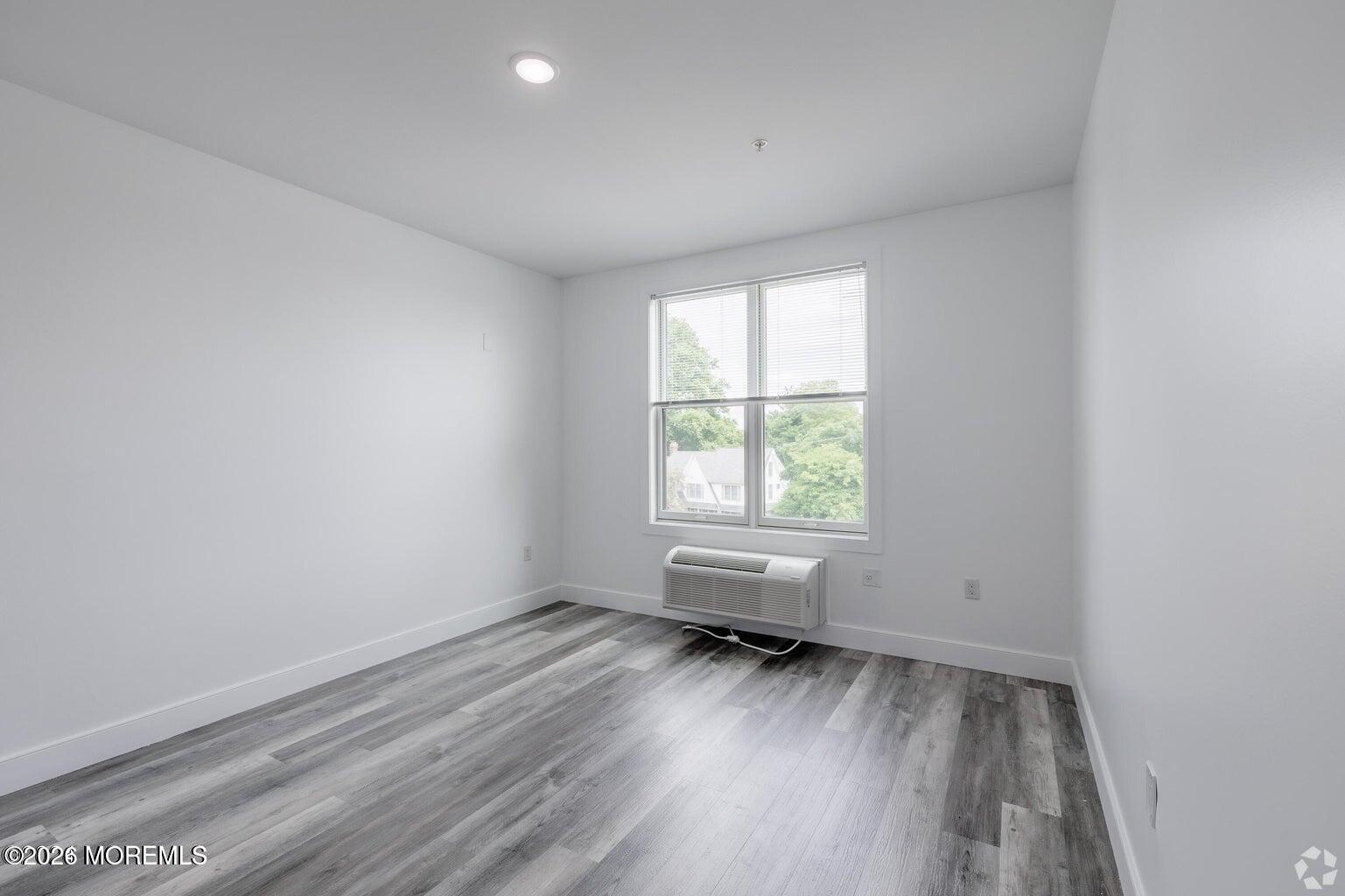 126 Main Street, Unit 311 Matawan, NJ 07747 - Photo 8 of 13 an empty room with wooden floor and windows