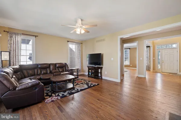 a living room with furniture a flat screen tv and a window