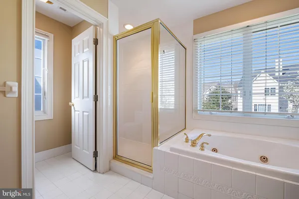 a bathroom with a tub a sink and a window