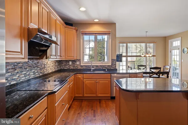 a kitchen with granite countertop a sink a counter space appliances and cabinets