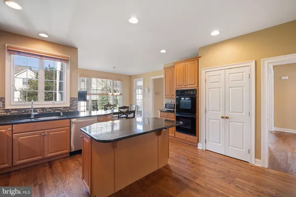 a large kitchen with kitchen island granite countertop a sink and refrigerator