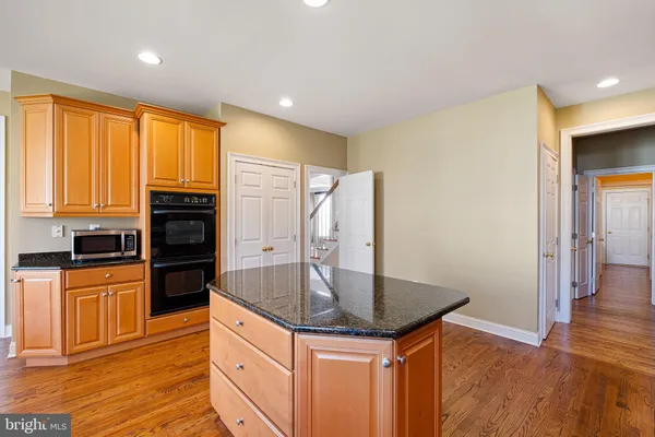 a kitchen with stainless steel appliances granite countertop a sink a stove and refrigerator