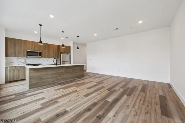 a view of kitchen with wooden floor and electronic appliances