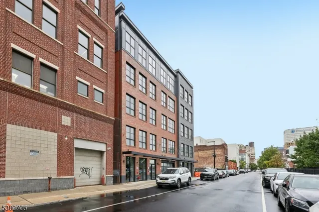 a city street lined with parked cars and buildings