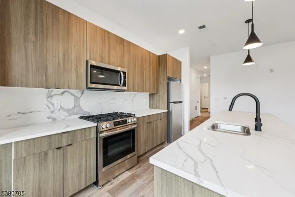 a large kitchen with kitchen island a large counter space a sink appliances and cabinets