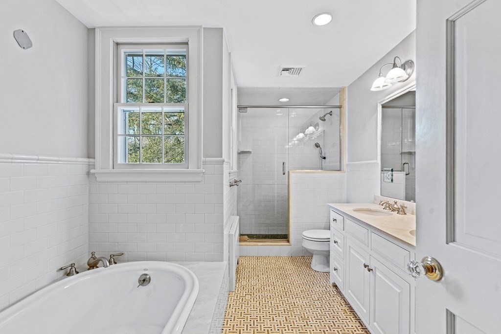 8 Old Farm Road Wellesley, MA 02481 - Photo 15 of 25 a bathroom with a tub a toilet a sink and a large mirror