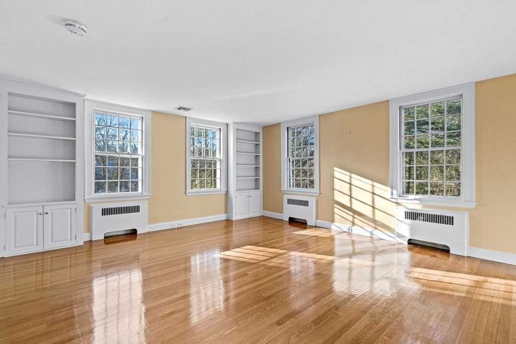 8 Old Farm Road Wellesley, MA 02481 - Photo 18 of 25 a view of an empty room with wooden floor and windows