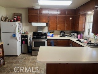 1127 West 23rd Street Merced, CA 95340 - Photo 5 of 14 a kitchen with a sink a stove and a refrigerator