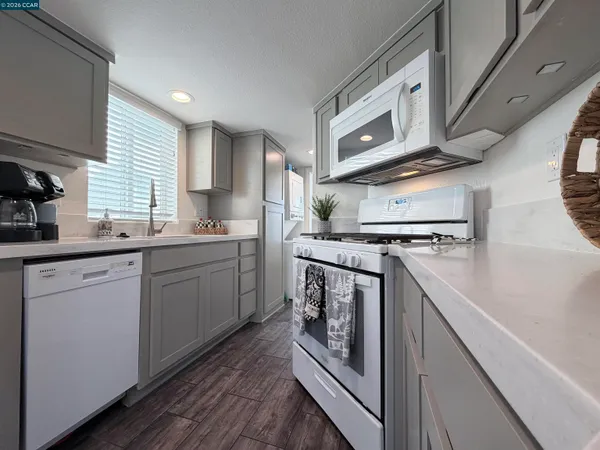 a kitchen with stainless steel appliances granite countertop a stove a sink and a microwave