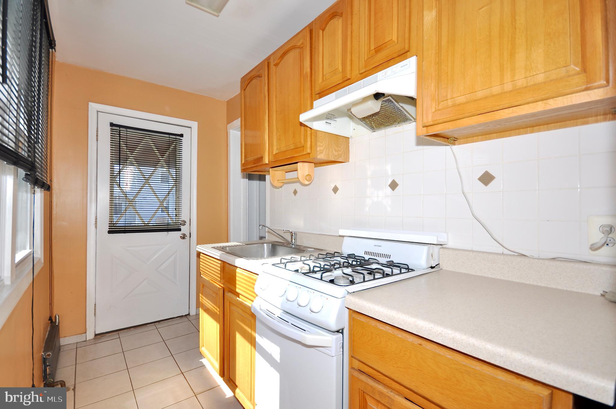 223 Ryers Avenue Cheltenham, PA 19012 - Photo 18 of 25 a kitchen with a stove a refrigerator and a cabinets