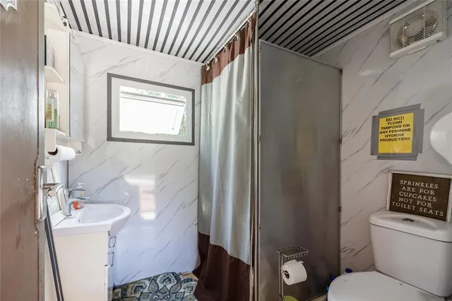 a living room with furniture a ceiling fan and a window