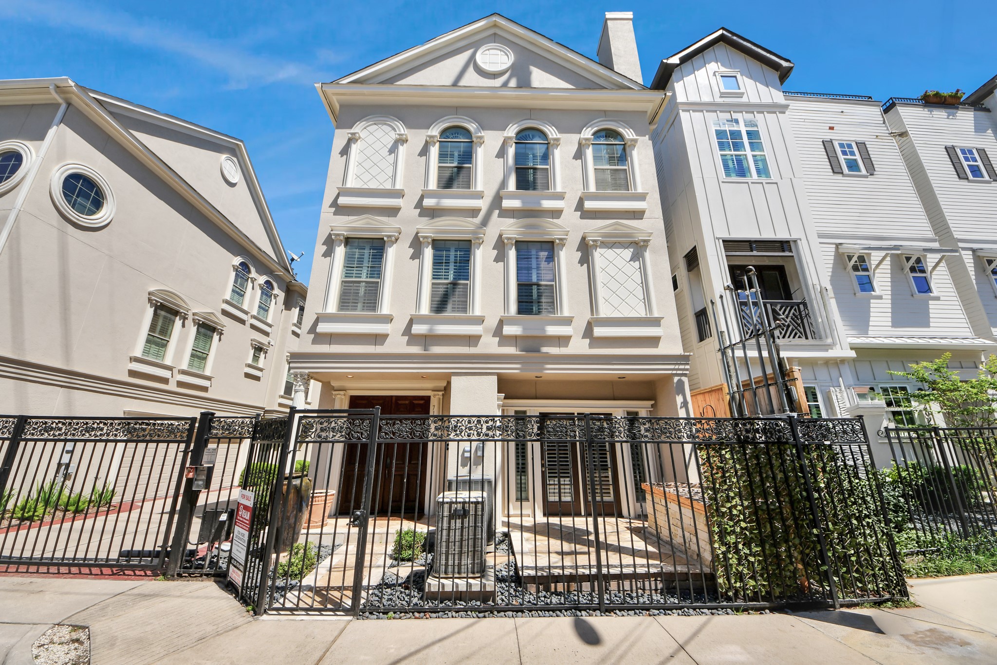 710 Jackson Hill Street Houston, TX 77007 - Photo 1 of 31 This is a classic, three-story townhouse with a clean stucco exterior and decorative trim. It features large windows for ample natural light. The property is enclosed by a stylish wrought-iron fence, offering both security and curb appeal.