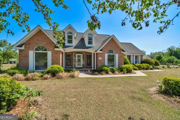 a front view of a house with yard and green space
