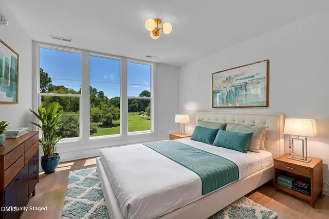 a bedroom with a large bed and a large window