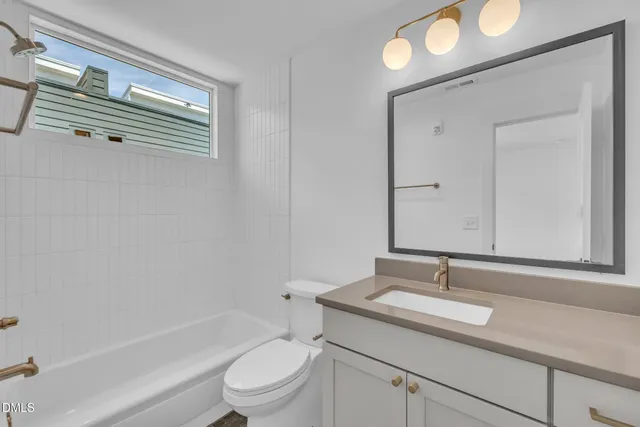 a bathroom with a granite countertop sink toilet a mirror and shower