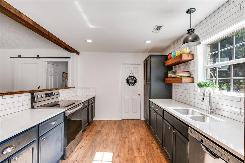 52 Castleman Road Carrollton, GA 30116 - Photo 11 of 35 a kitchen with stainless steel appliances granite countertop a sink stove and cabinets
