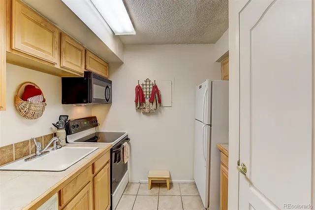 a view of a kitchen with sink and refrigerator