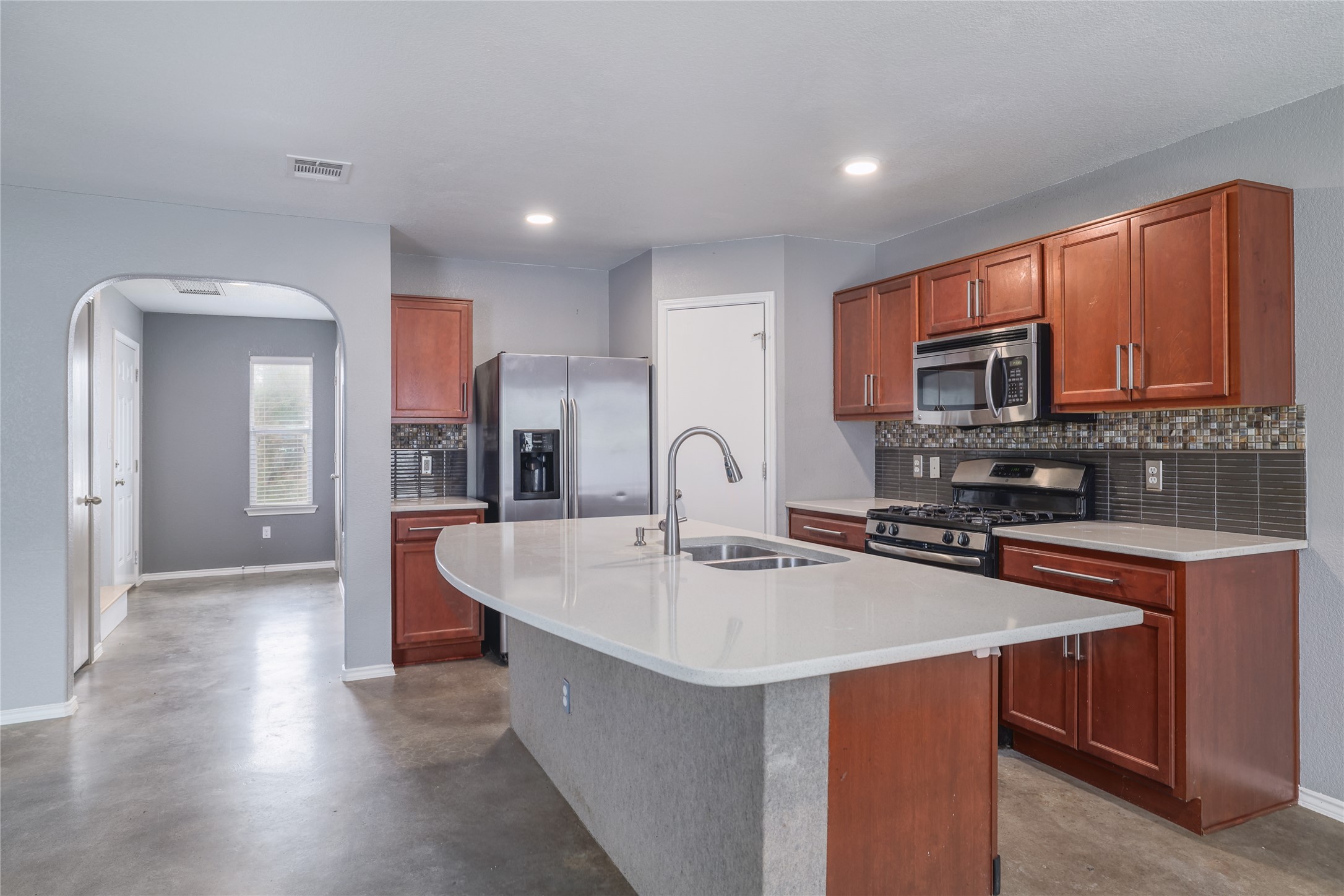 4625 Credo Lane Austin, TX 78725 - Photo 6 of 34 Contemporary kitchen featuring a large island with an undermount sink and gooseneck faucet