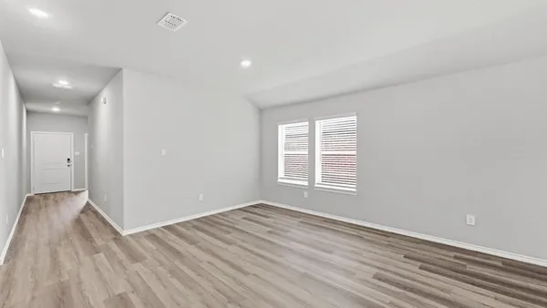 a kitchen with a refrigerator and white cabinets