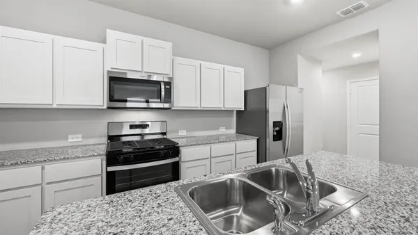 a kitchen with a refrigerator sink and cabinets