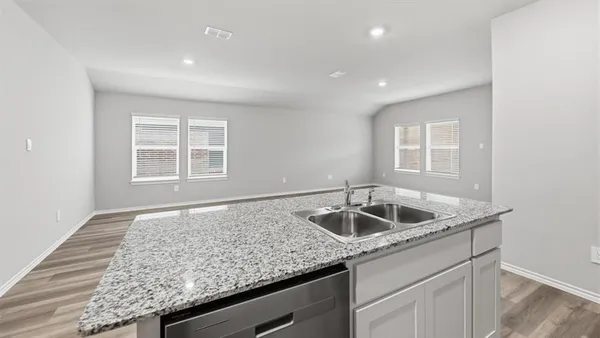 a kitchen with granite countertop a sink stove and cabinets
