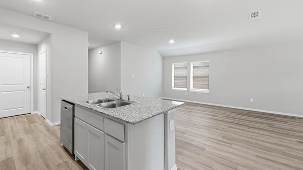 a kitchen with granite countertop a stove and a microwave